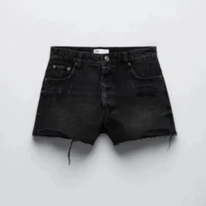 Svarta jeansshorts ZARA - Snygga svarta jeansshorts med slitna detaljer och råa kanter. Perfekta för en avslappnad stil. De har en klassisk femficksdesign och knappgylf. Aldrig använda