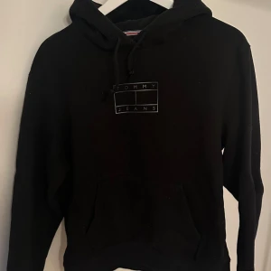 Svart hoodie från Tommy Jeans - Stilren och snygg hoodie från Tommy Hilfiger. Storlek M men sitter mer som S/XS❤️‍🔥 