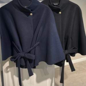 Snygg och stilren cape från Missay i svart. Den har en elegant knäppning med guldknapp och ett knytband i midjan för en chic look. Använder inte lika mycket längre men den är jätte fin och perfekt inför våren💞