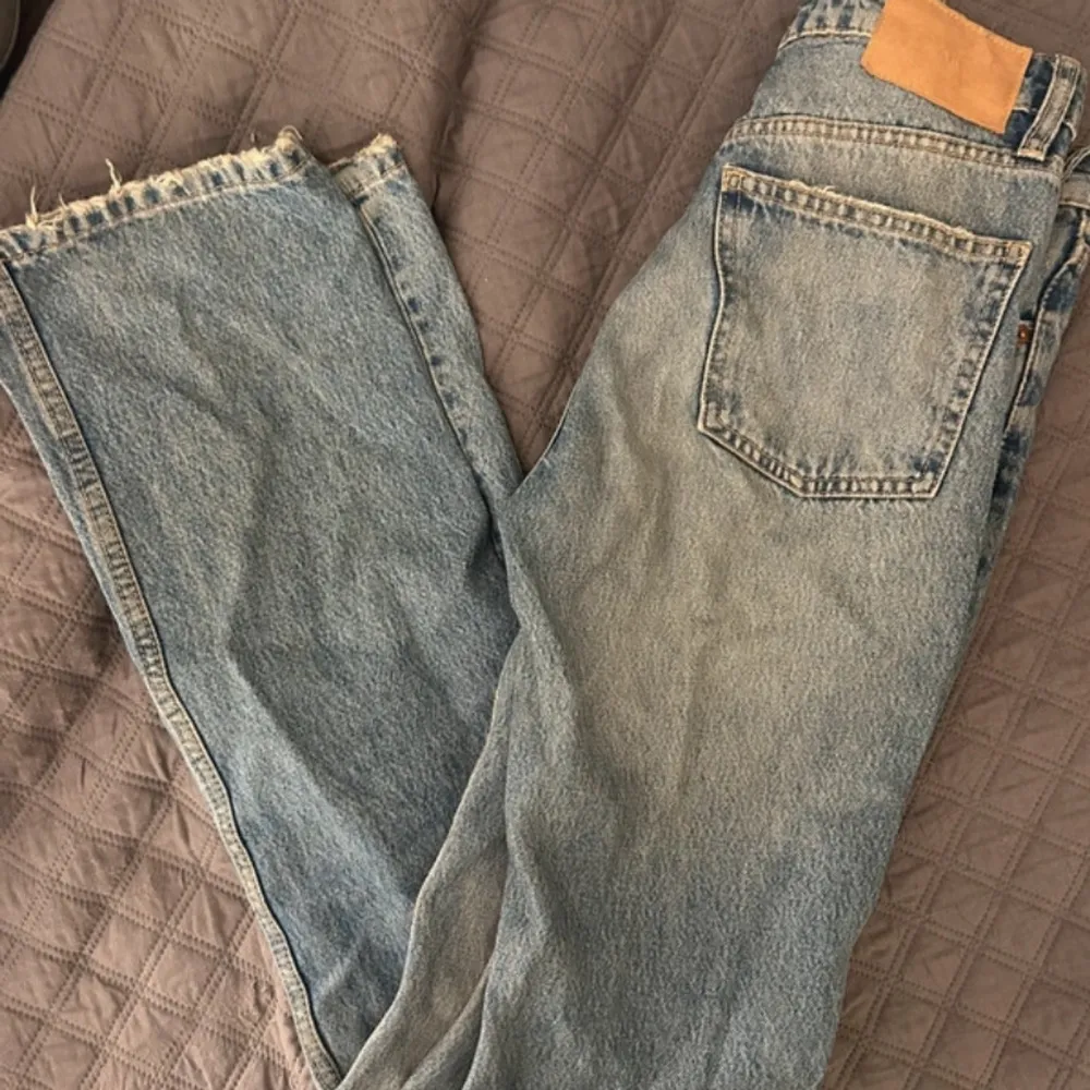 Snygga blå jeans från ZARA med en klassisk femficksdesign och knappgylf. Jeansen har en ljus tvätt och raka ben med råa kanter vid bensluten för en trendig look, jätte fina låg midjade använt några gånger ser ut som nya . Farkut & Housut.