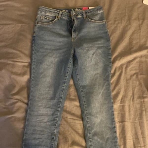 Blå jeansbyxor - Snygga blå jeansbyxor med klassisk femficksdesign och knappgylf. De har en smal passform och är perfekta för en avslappnad stil. Byxorna har en lätt tvättad look som ger dem en trendig touch.