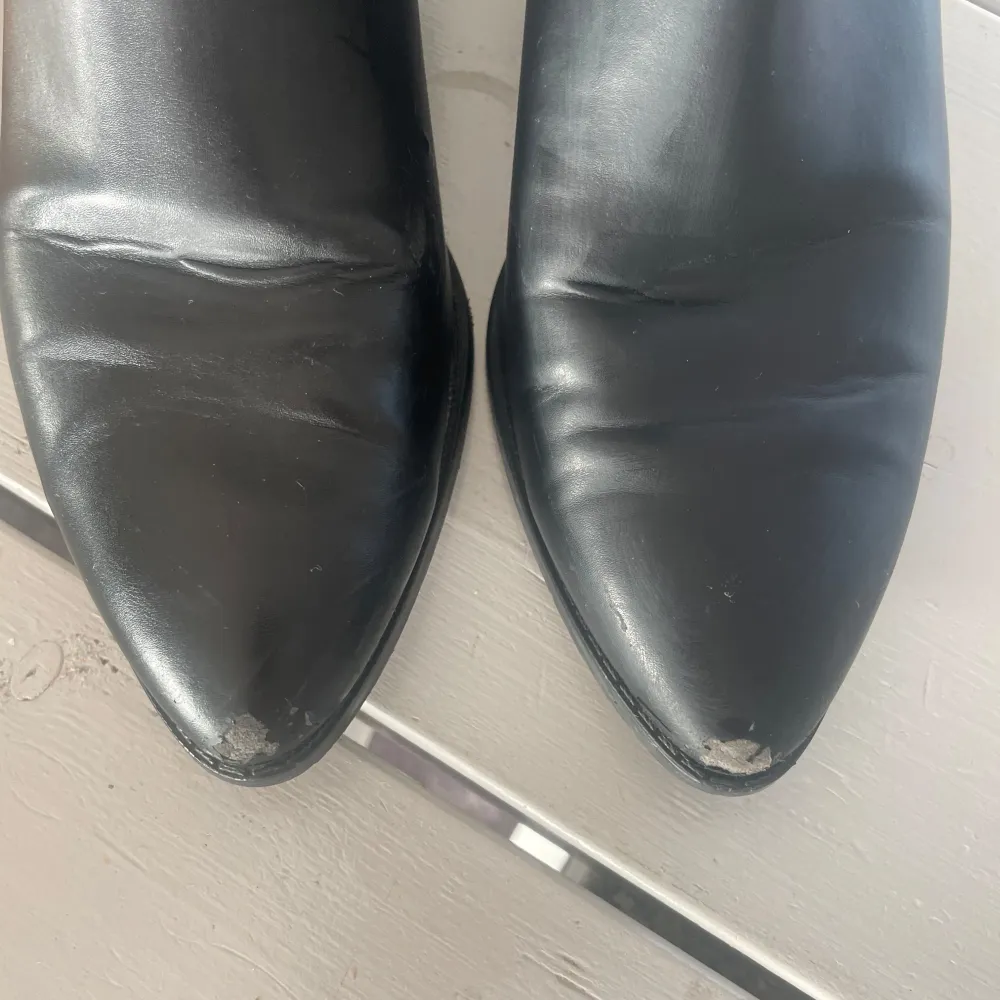 Snygga svarta boots i skinn med spetsig tå och bred klack. De har en klassisk design med dragöglor upptill för enkel påtagning. Tecken på användning med lite slitage längst fram (se bild). Nypris 699💞. Kengät.