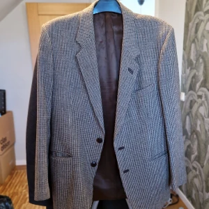 Rutig kavaj med armbågslappar - Snygg rutig kavaj med klassiska armbågslappar. Kavajen har två knappar framtill och fickor. Perfekt för en stilren look.