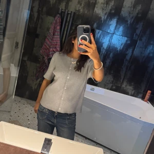 Grå kofta med knappar - Säljer en söt ljusgrå kofta med korta ärmar och knappar framtill. Den är i storlek Medium men passar lika bra som en Small och passar bra till både jeans och kjol. Aldrig använd men ingen prislapp på💕