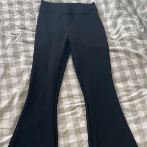 Svarta bootcut byxor - Snygga svarta bootcut byxor med hög midja. Perfekta för en stilren look. Byxorna har en skön passform och är tillverkade i ett mjukt material.