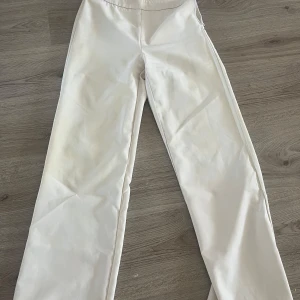 Vita kostymbyxor - Snygga vita kostymbyxor med rak passform. Perfekta för en stilren look. De har en enkel design utan extra detaljer och är gjorda i ett bekvämt material.