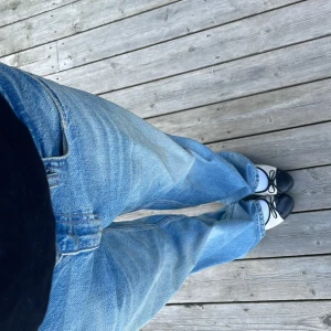 Blå populära straight jeans - Säljer ett par klassiska blå jeans med rak passform. Jeansen har fem fickor och är tillverkade i slitstarkt denim. Passar till sneakers eller ballerinaskor.