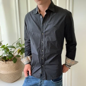 Burberry skjorta svart L - Skön burberry skjorta i storlek L. Sitter bra på mig som är 180,75 kg. Är använd, men inga större defekter! 