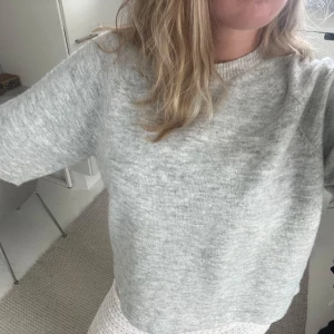 Grå stickad T-shirt  - Supermjuk ljusgrå stickad tröja med avslappnad loose passform och rund halsringning. Perfekt för lager-på-lager och chill dagar. Långa ärmar och enkel design som funkar till allt.