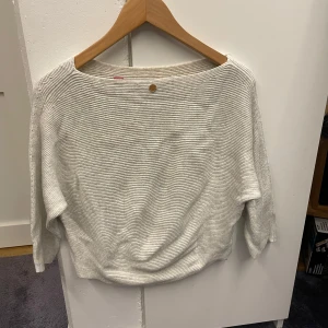 Vit ribbad stickad tröja s.Oliver - Säljer en vit stickad tröja från s.Oliver i storlek S. Tröjan har ett ribbat, randigt mönster och trekvartsärmar. Den har en avslappnad passform och rundad halsringning, perfekt för dig som gillar enkel och stilren design.