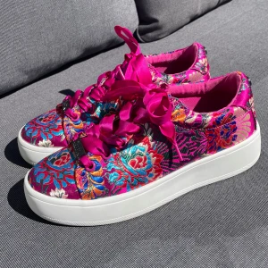 Steve Madden blommiga sneakers med platåsula - Färgstarka sneakers från Steve Madden med blommigt mönster i rosa, blått, orange och guld. Skorna har breda satinsnören, vit platåsula och rund tå. Ovandelen är i glansigt tyg med broderade detaljer som verkligen sticker ut.Använda varsamt 1-2 gånger. Mycket bra skick!