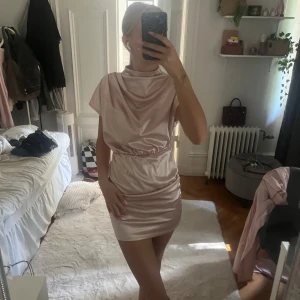 Ljusrosa satin kortklänning - Supersnygg ljusrosa kortklänning i satin. Aldrig använd 