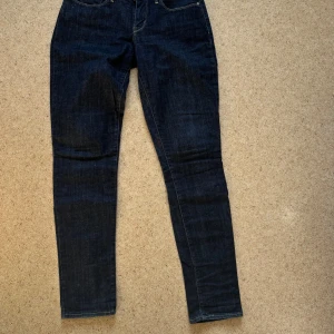 Levis Bold Curve Stretch, W28 L32 - Superbra skick på dessa Levis Bold Curve Stretch i mörkblå tvätt med klassisk femficksdesign och raka ben. Jeansen har en snygg, slim/skinny passform och framhäver konturer! Storlek 28/32.