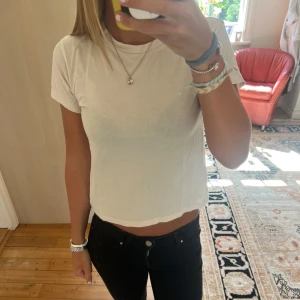 Vit/beige t-shirt - Säljer en enkel och fräsch vit/beige t-shirt med rund hals. T-shirten är gjord i mjuk bomull och har en clean look som passar till jeans eller shorts.💛
