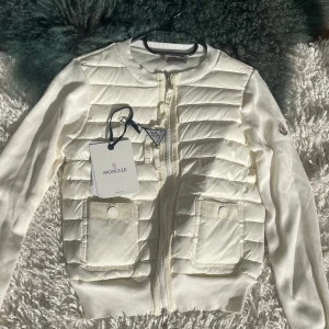 Vit moncler pufferjacka - Utmärkt skick, säljer en vit pufferjacka från moncler med quiltad framsida och ärmar i stickad bomull. 