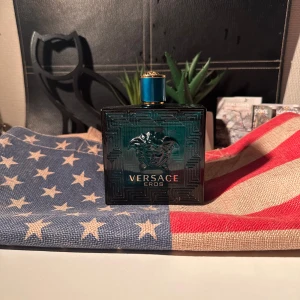 Versace Eros Eau de Toilette 200ml - Versace Eros Eau de Toilette i en lyxig, turkosblå glasflaska med Medusa-huvud i relief och gulddetaljer på korken. Flaskan har en fyrkantig form och rymmer 200 ml. En ikonisk herrdoft med elegant design som sticker ut på hyllan. Har använt i ett litet tag, men dags att sälja. Kommer inte med förpackning.