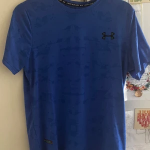 Blå Under Armour t-shirt - En fin blå under armour t shirt. Materialet är jätte mjukt och skönt. Perfekt för dig som vill avsluta sommaren med stil. Storlek M men passar Storlek S perfekt också. Aldrig använd sprillans ny