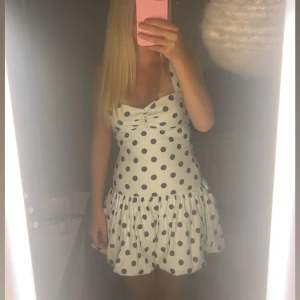 Vit prickig kortklänning med volang - Supersöt vit kortklänning med svarta prickar. Superbra skick och är endast använd två gånger. Från Zara och säljs inte längre. Storlek s❤️