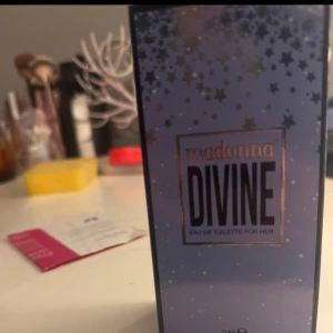 Madonna Divine Eau de Toilette - Madonna Divine Eau de Toilette for Her, 50 ml. Lila förpackning med stjärnmönster och guldiga detaljer. Doften är feminin och passar dig som gillar en lyxig känsla. Snygg box att ha framme på sminkbordet. Den är oöppnad också oj jag fick den i present men den är inte min doft det är manlig doft