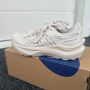 Vita/Beiga Asics GT-2000 14 löparskor - Nästan helt nya Asics GT-2000 14 sneakers. Knappt sprungit 2 km i de. Jättebra löparskor men passar tyvärr inte mina fötter. Hade kunnat behålla de för att gå men är lite för dyra för det. De är i storlek 38 och färgen Oatmeal/White. Skickas med orginalkartongen. Säljer även Asics gel kayano 32 i samma storlek och skick! Paket pris på 2500kr på båda då gel kayano 32 är dyrare:) 
