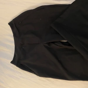 Svarta bootcut från Ninepine XXS - Svarta leggings från Ninepine i storlek XXS. De har en clean look med hög midja och stretchigt material som sitter tajt och bekvämt. Perfekta för chill eller träning, och funkar till allt i garderoben.