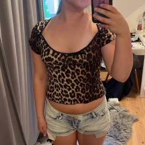 Leopardmönstrad  topp med rosett - Säljer en topp med leopardmönster. Toppen har en söt liten rosett framtill och en rundad urringning med dekorativ kant.💞