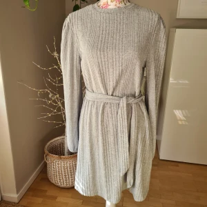 NY, mysig, långärmad klänning - Ny/oanvänd. Mjukt, lite smått ludet tyg utanpå. Resår i ärmsluten, knytband i midjan, liten puffärm. Passar S/M. ~ STOR rensning & klänningsbonanza i min shop ~ Välj 5 för 100kr oavsett pris, skicka medd/lämna som prisförslag (gäller där det står) ~