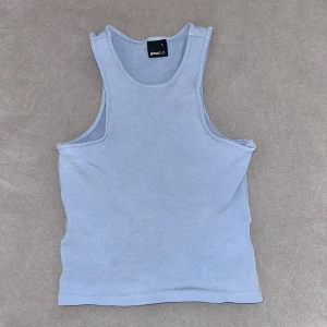 Ljusblå linnetopp från Gina Tricot - Säljer en enkel och stilren ljusblå linnetopp från Gina Tricot. Toppen är ärmlös med klassisk rund halsringning och har en tight passform. Perfekt att matcha med jeans eller kjol för en clean look.