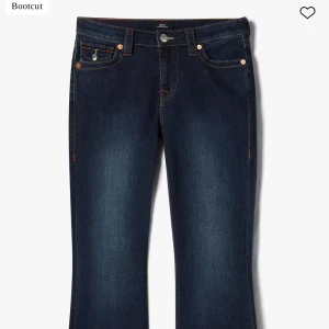 Mörkblå bootcut jeans från True Religion - Säljer ett par mörkblå bootcut jeans från True Religion med klassiska kontrastsömmar och detaljerade bakfickor med lock och knapp. Jeansen har fem fickor och orange sömmar som ger en snygg kontrast. Originalpris 1 399kr i butik. (Endast testade) storlek 27/32 så passar både S och M (36/38)💕