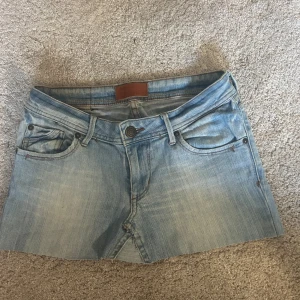 Ljusblå lågmidjad jeanskjol TRYCK INTE PÅ KÖP NU - As snygg lågmidjad jeans kjol. Är något ojäm längst ner då jag klippt av den så den skulle vara något kortare men rättas lätt till och är inget som märks eller syns när den sitter på.passar xs-m då den är stretchig