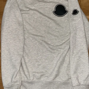 Grå Moncler Sweatshirt - Säljer en  ljusgrå sweatshirt från Moncler med en svart logga på bröstet. 