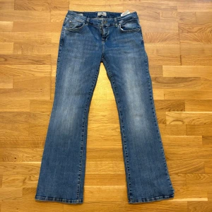 Blå bootcut jeans från LTB - Säljer ett par klassiska blå jeans från LTB, modell Roxy. Jeansen har bootcut passform, fem fickor och låg midja i storlek 29/30.