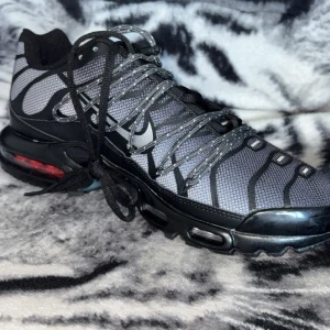 Nike Air Max Plus Tn sneakers i svart och grå - Säljer ett par Nike Air Max Plus Tn sneakers i svart och grå med reflekterande detaljer och synlig Air Max-dämpning. (De finns en liten defekt på baksidan av skon där det är där inne i luft dämpningen ) ”Finns på bilden, men hel nya” Replika