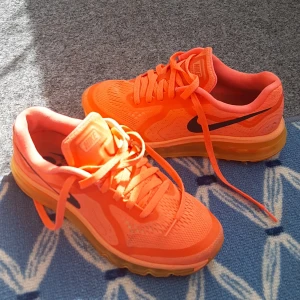 Nike Air Max sneakers i orange - Säljer ett par Nike Air Max sneakers i en riktigt snygg orange färg med svart swoosh. Skorna har snörning och en genomskinlig, dämpad sula. Perfekta för dig som vill sticka ut med färg på fötterna. Ovandelen är i mesh och syntetmateria. skor är mycket lätta och bekväma mycket bra skick.