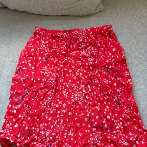 Röd blommig kjol från Holly & Whyte - Säljer en röd kjol från Holly & Whyte med mönster i storlek S❤️Använd enstaka gång