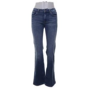 Blå bootcut jeans - Ett par klassiska blå jeans med bootcut passform. Jeansen har fyra fickor, normal/låg midja och raka ben som blir vida nedtill