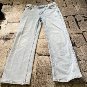 Ljusblå wide leg jeans från Never Denim - Säljer ett par ljusblå jeans från Never Denim med wide leg och midwaist. Jeansen har klassisk femficksdesign och raka ben. Perfekta för dig som gillar en avslappnad och trendig stil.