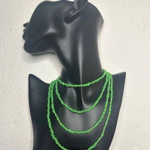 Vintage grönt pärlhalsband – Retro 60-tal, färgstarkt & extra långt - Vintage pärlhalsband från 60-/70-talet, inropat på auktion. Ca 140 cm långt med små, klargöna pärlor (ca 0,5 cm) i varierad form som ger ett livfullt uttryck. Kan bäras långt eller viras flera varv för personlig stil. Fint skick med stark färg och glans – perfekt för dig som gillar retro, färg och lekfulla detaljer. Prutning accepteras ej, men jag erbjuder rabatt vid köp av flera saker. Rensar garderoben – kolla gärna mina andra annonser också!  
