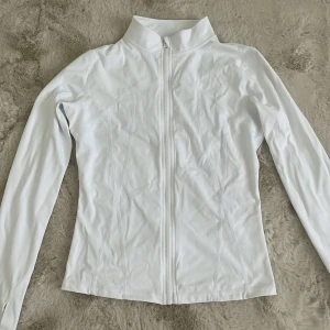 Träning tröja - Vit tränings kofta med en tight passform, aldrig använd och säljs då den inte kommer till använding.