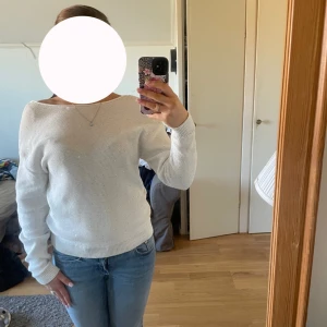 Vit stickad tröja med öppen rygg - Säljer en stilren vit stickad tröja med en elegant öppen rygg. Tröjan har långa ärmar och en bekväm passform. Perfekt för en sommarkväll. Köpt förra året för cirka 500 kr och endast använd två, tre gånger. 