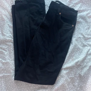 Svarta byxor från H&M - Snygga svarta byxor från H&M i storlek 36. Perfekta för en stilren look med en klassisk passform. Byxorna har en enkel design med fickor och knappdetaljer.