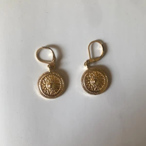 Guldörhängen med solmönster - Snygga guldörhängen med ett detaljerat solmönster.  Aldrig använd.