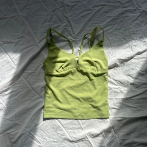 Grön linnetopp från Zara - Snygg grön linnetopp från bikbok med smala axelband och djup urringning. Perfekt för varma sommardagar. Toppen är i ett mjukt och stretchigt material