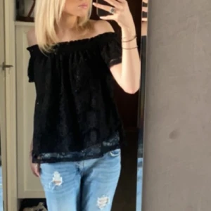 Svart offshoulder topp - Säljer min svarta offshoulder topp med spetsdetaljer. Den är i bra skick och har inga större defekter. Skriv vid fler frågor🩷