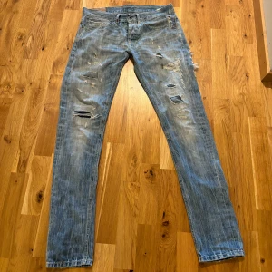 Dondup  - Riktigt snygga ljusblå dondup med riktigt schyssta slitningar. Fint skick, har haft hål i skrevet men det är lagat och syns numera ej! Storlek W32, men sitter som 29/32