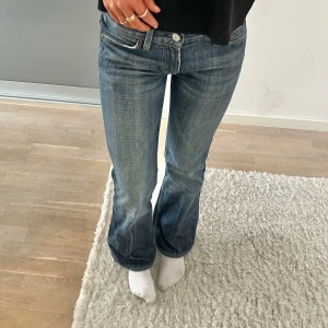 Blå bootcut jeans - Snygga blå bootcut jeans med klassisk femficksdesign och dekorativa sömmar på bakfickorna. Perfekta för en avslappnad stil.