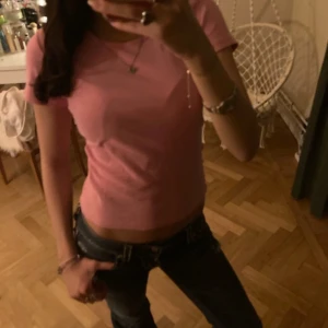 Rosa kortärmad topp - Säljer en söt rosa kortärmad topp. Perfekt för en avslappnad stil och kan enkelt matchas med jeans eller kjol. Toppen har en enkel design och är gjord i ett mjukt material för extra komfort.