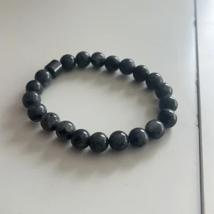 Grått pärlarmband - Snyggt grått armband med runda pärlor. Perfekt för att ge en stilren touch till din outfit. Elastiskt band för enkel passform.