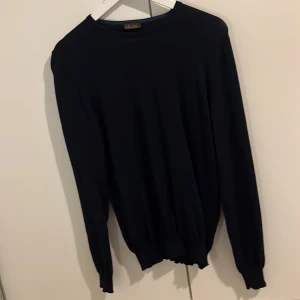 Mörkblå tröja från Stenströms - Säljer en stilren mörkblå tröja från Stenströms. Tröjan har långa ärmar och en klassisk rund halsringning. Perfekt för en elegant och avslappnad look, storlek M