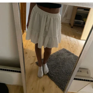 Vit kortkjol  - Säljer denna söta kjolen som kommit till användning endast 1 gång! Kjolen har snören som detalj men går ej att spänna åt banden, hör av er via intresse eller frågor 💕💕 passar perfekt för sommaren!!